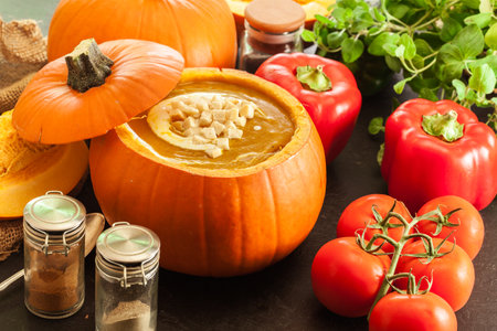 Pumpkin soup with cream in a pumpkin for autumn dinnerの写真素材