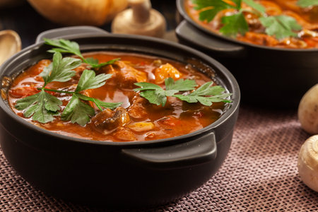Stew soup with meat, potatoes, mushrooms and red pepper in bowlの写真素材