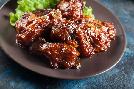 Sweet and spicy chicken wings on a plateの写真素材