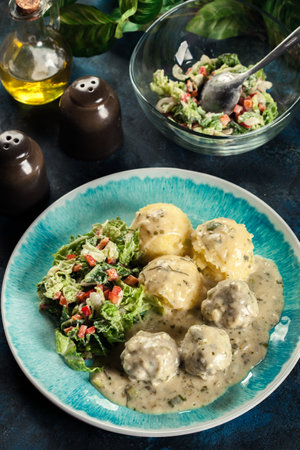 Meatballs with creamy and cheese gravy served with mashed potatoes balls and saladの写真素材