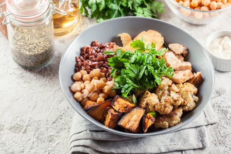 Buddha bowl lunch with chicken and red rice, chickpea, cauliflower and Halloumi cheese. Healthy food conceptの写真素材