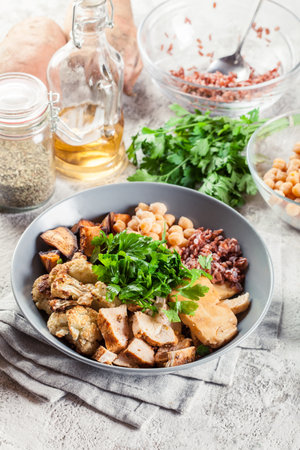 Buddha bowl lunch with chicken and red rice, chickpea, cauliflower and Halloumi cheese. Healthy food conceptの写真素材