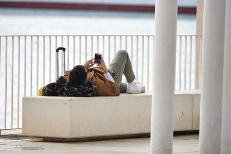 quiet man lying with cellphoneのeditorial素材