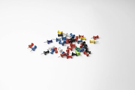 still life pushpins of different colors on white background