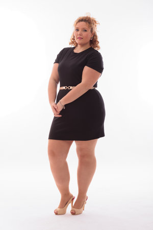 Plus size woman wearing black dress and high heels, white background
