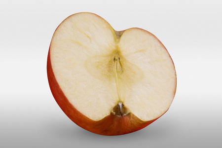 Half of a red apple on white background in a front view with clipping pathの写真素材