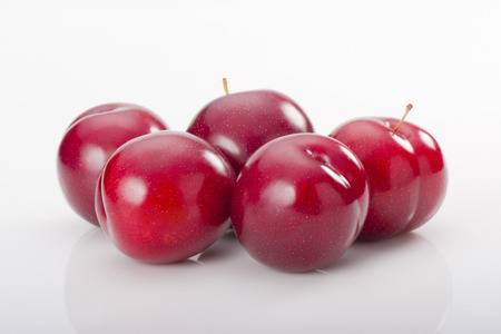 Red plums on white background. Studio shoot.の写真素材