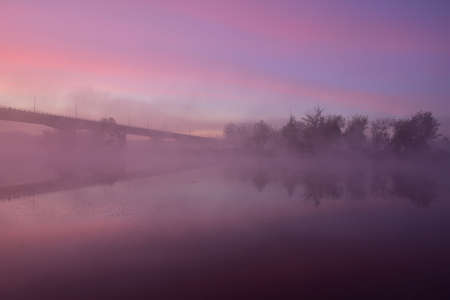 Sunrise, the outline of the bridge in the fog, a mysterious view. Fog.の写真素材