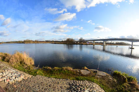 Calm water and clouds in the sky reflecting in the water. Spring.