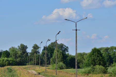 Broken electric wires on the pole and on the lamp. Summer.
