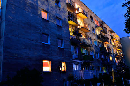 House at night among trees lit by street lamps. City,