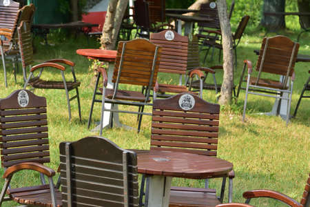 Zywiec. Benches among trees and grasses with the Å»ywiec sign. Summer.のeditorial素材