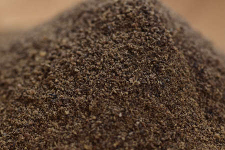 Ground pepper on a wooden bowl against a white background. Food.の写真素材