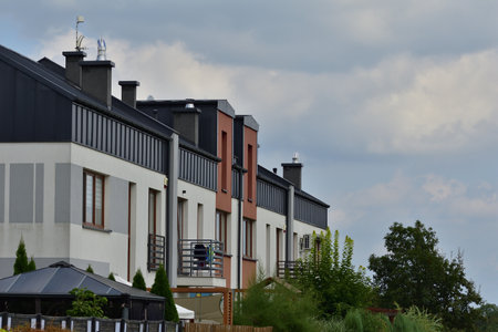 Multi-family houses among trees and cars overcast day. It's live.の写真素材
