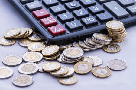Coins and calculator on an isolated white background.の写真素材