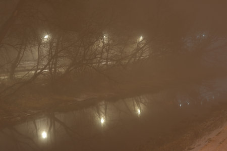 Fog in the city in the evening illuminated by street lamps. Night.の写真素材