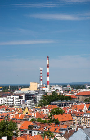 Wroclaw Old Town and industrial chimneys in the background on a sunny day.