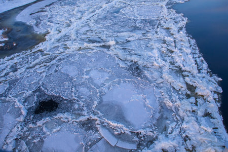 Ice-bound river and floating floe on a sunny frosty winter day.の写真素材