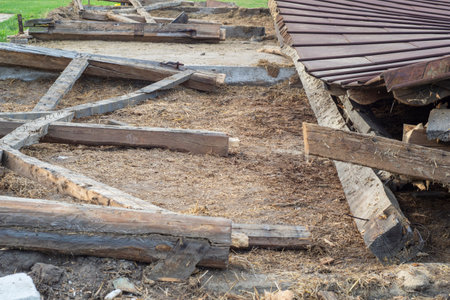 The remains of an old, destroyed metal roof lie on the ground after the demolition of the barn. Day