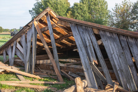 The remains of an old, destroyed metal roof lie on the ground after the demolition of the barn. Dayの写真素材