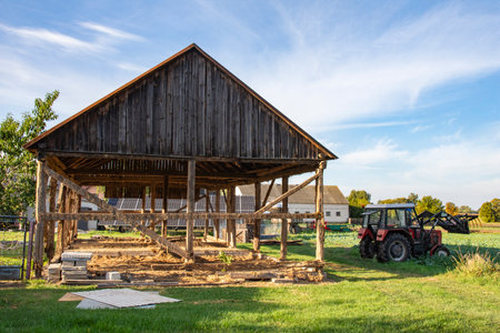 The skeleton of an old, destroyed barn being demolished on a sunny day. Grassの写真素材