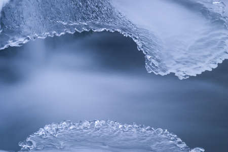pattern of ice in creek with silky water flowingの写真素材
