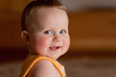  happy baby boy 7 months old laughing, looks towards cameraの写真素材
