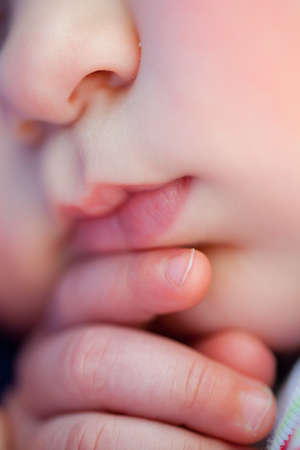 closeup of  baby sleeping showing part of face and hands, shallow dopの写真素材