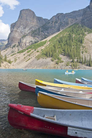 canoes on moraine lake with rocky mountains in backgroundの写真素材