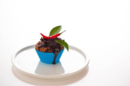 Hot chocolate cupcake with liquid chocolate and a red chili as a studio shootingの写真素材