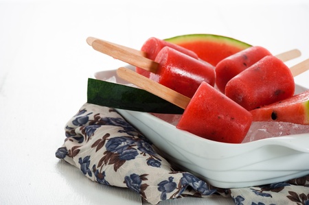 watermelon popsicle in a white bowl with ice and fresch watermelonの写真素材