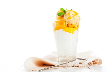Mango ice cream with fresh mango and whipping cream in a glassの写真素材