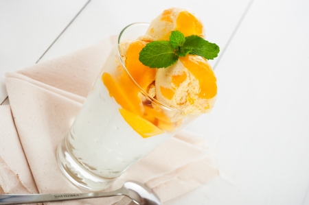 Mango ice cream with fresh mango and whipping cream in a glassの写真素材