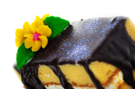 Small piece of three layer vanilla cake with cream and chocolate  Flower as decoration on the top ...