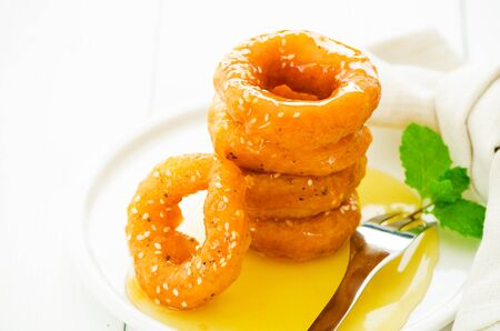 Mini donuts doing with rice flour soaked with honey on white plate. Typical thai dessertの写真素材