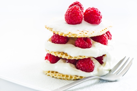small raspberry cake with cream on white background
