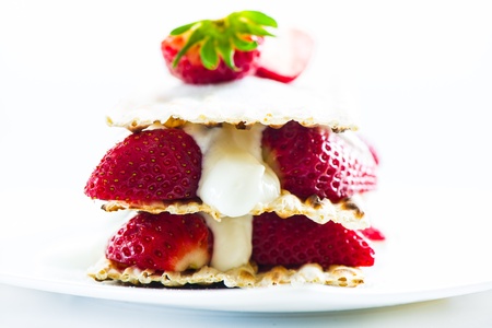 small strawberry cake with cream on white background