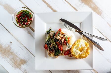 Thai spicy food basil pork fried with rice and fried egg and chili fish sauce,Pad Kra Pao mooの写真素材