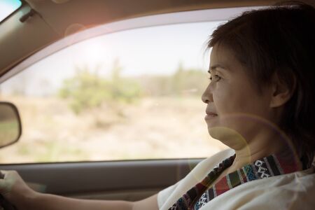 Woman drives car and looks focused on the roadの写真素材