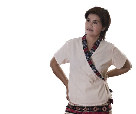 One grinning middle aged adult Asian woman with hands on hips and satisfied or thoughtful expression over white backgroundの写真素材