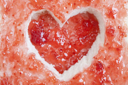 Slice of bread with fruit jam heart shapeの写真素材