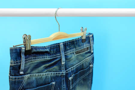 Blue jeans trouser hang on hangerの写真素材