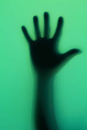 Hand silhouette on green glassの写真素材