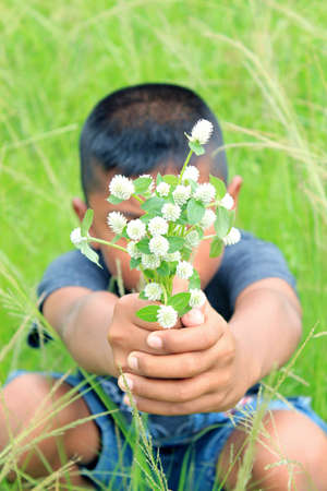 Boy holds white globe amaranthの写真素材