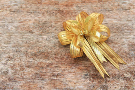 Golden Ribbon on old wood backgroundの写真素材