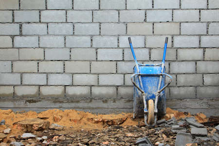 Old rusty wheelbarrow in construction siteの写真素材