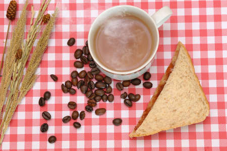 Cup of coffee and coffee beans on tartan backgroundの写真素材
