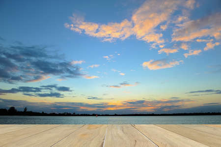 wooden desk table with blurred sunsetの写真素材