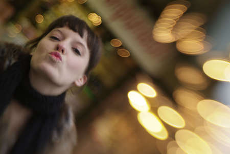 a young woman is kissing in the air with blurry backgroundの写真素材