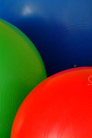 gym balls in blue red and green on the floorの写真素材